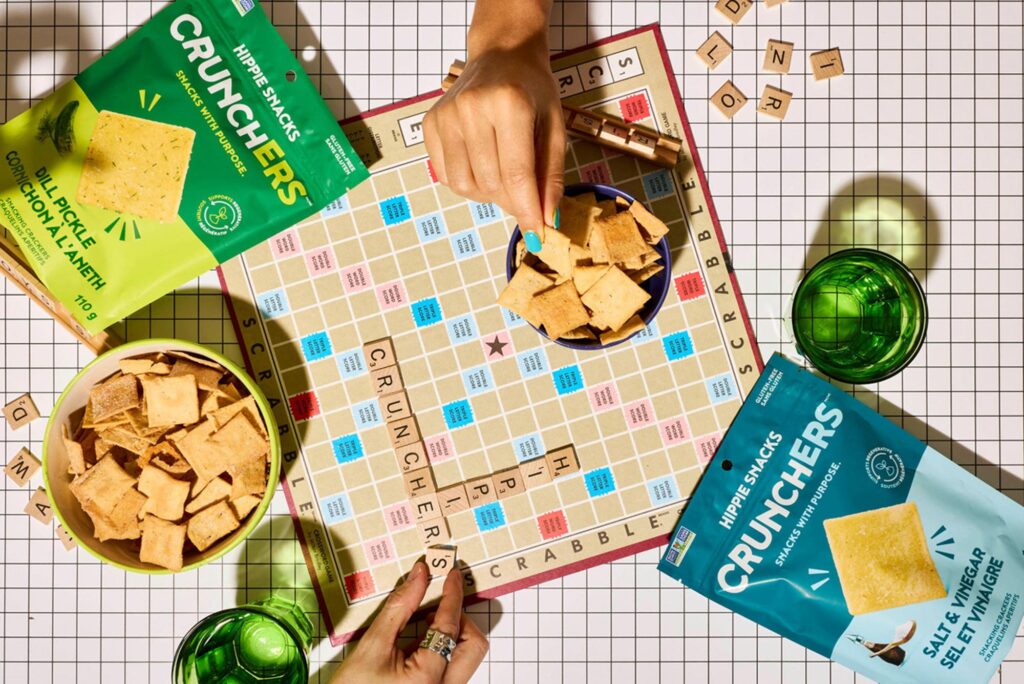 Scabble board with a hand grabbing a crunchers snack